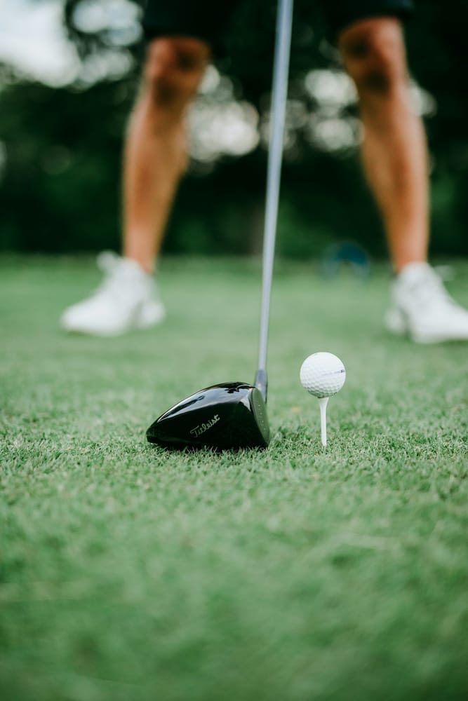 Golf ball next to a club, ready for tee-off
